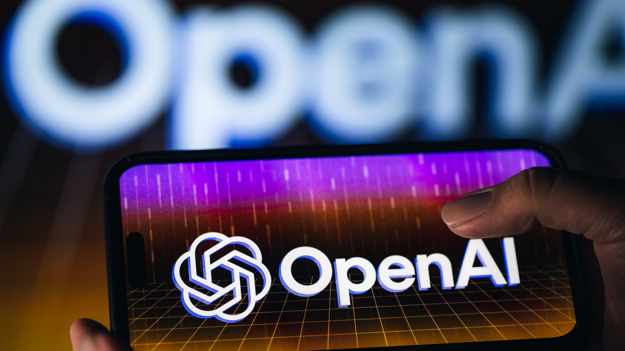 手持屏幕上带有 OpenAI 标志的智能手机的人